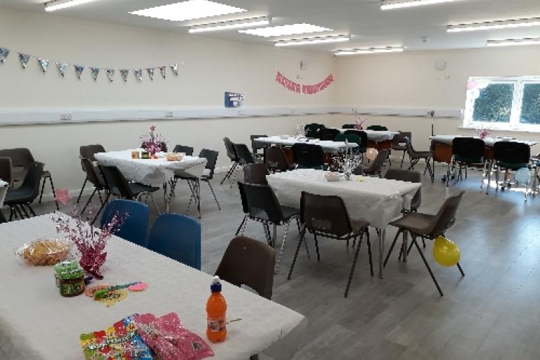 Lydiate room with tables set out and decorated for a party