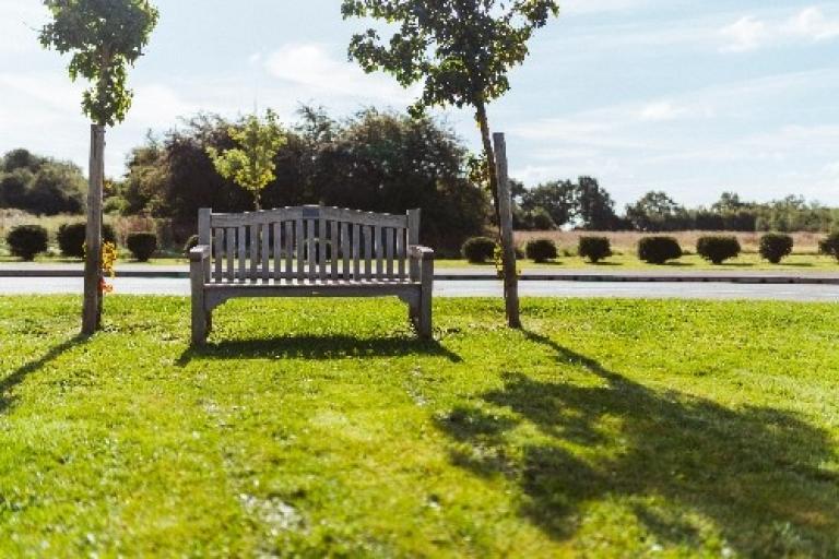 Wooden memorial bench at Strawberry Lane Cemetery