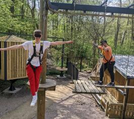 children balancing on low ropes platforms and ropes
