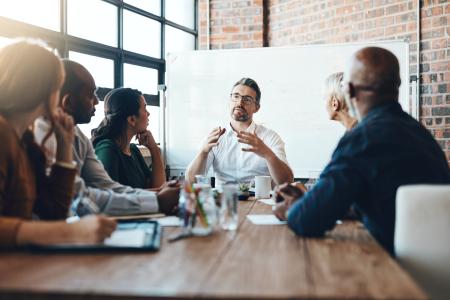 Stock image of business people sat in a board room meeting